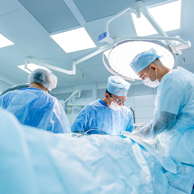 Three surgeons performing surgery